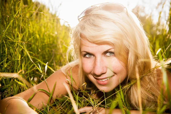 Sonriente joven mujer arrastrándose a través de la hierba alta — Foto de Stock