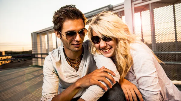 Couple amoureux au coucher du soleil sur un garage Images De Stock Libres De Droits