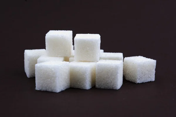 Bunch of white lump sugar on a brown background Stock Image