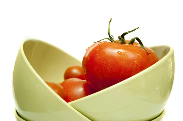 Tomates rojos en un plato verde sobre un fondo blanco —  Fotos de Stock