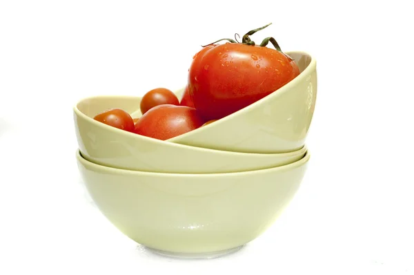 Rote Tomaten auf grünem Teller auf weißem Hintergrund — Stockfoto