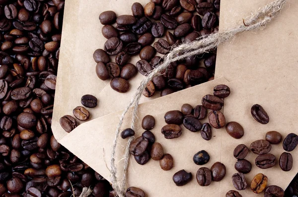 Granos de café en un sobre de papel —  Fotos de Stock