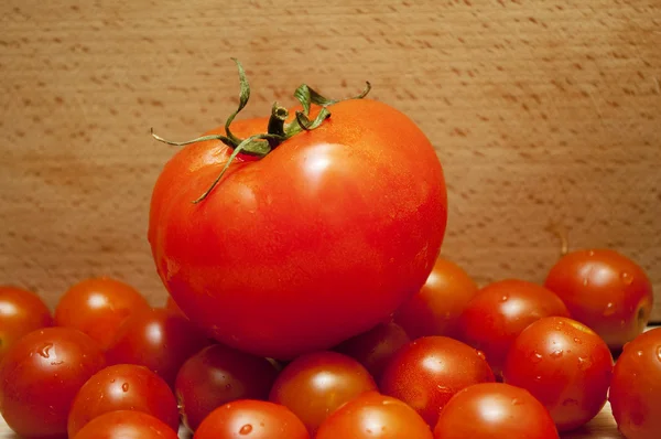Великий червоний помідор на маленьких помідорах — стокове фото
