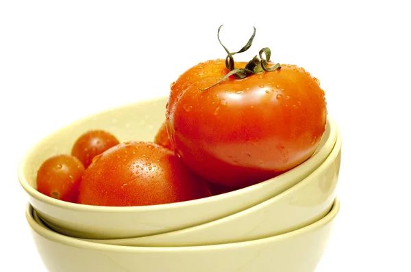 Tomates rojos en un plato verde sobre un fondo blanco — Foto de stock gratis