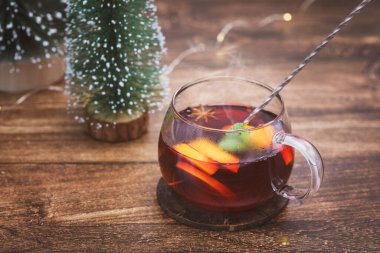 Noel, yeni yıl kompozisyonu bir fincan alkolsüz sıcak şarapla narenciye dilimleri ve tatil dekoruyla. Sıcak, sağlıklı bir içecek. Kış tatili içkisi