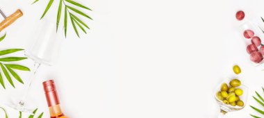 Boş şarap kadehiyle yemek afişi, bir şişe gül şarabı, yeşil zeytin, üzümler ve arka planda fotokopi alanı olan palmiye yaprakları. Tropikal tatil beldesi konsepti ve rahatlama. Yaz partisi