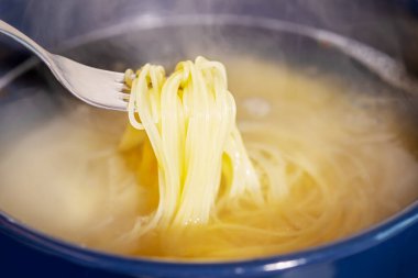 Spagetti pişiriyorum. Spagetti bir tencerede kaynar suda pişirilir. Geleneksel İtalyan yemekleri. Makarna yapıyorum.
