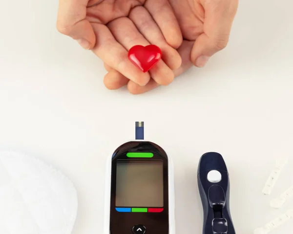 糖尿病対策 血糖値計と糖尿病性疾患の概念 血糖値を決定するためのテストストリップ 装飾的な心を持つレンズ豆や子供の手 ソフトフォーカス — ストック写真