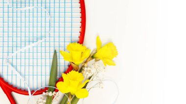 Tenis mi? Tenis raketi ve bir buket nergisle birlikte beyaz arka planda fotokopi alanı olan tatil spor kompozisyonu. Spor ve sağlıklı yaşam tarzı. Açık hava sporları konsepti. Tenis arka planı