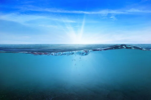 BLUE UNDER WATER waves and bubbles. Beautiful white clouds on blue sky over calm sea with sunlight reflection, Tranquil sea harmony of calm water surface. Sunny sky and calm blue ocean.