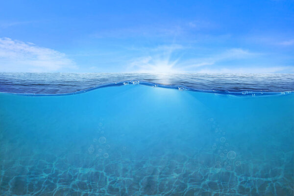 Волны и пузыри синей воды. Белые облака на голубом небе над спокойным морем с солнечным светом, спокойная морская гармония спокойной водной поверхности. Солнечное небо и спокойный голубой океан. 