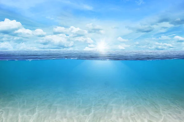 BLUE UNDER WATER waves and bubbles. Beautiful white clouds on blue sky over calm sea with sunlight reflection, Tranquil sea harmony of calm water surface. Sunny sky and calm blue ocean.