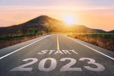 2023 'ü gün batımında asfalt yolun ortasındaki otoyolda yazmaya başla. 2022-2023 için planlama ve meydan okuma kavramı, iş stratejisi, fırsat, umut, yeni bir hayat değişimi..
