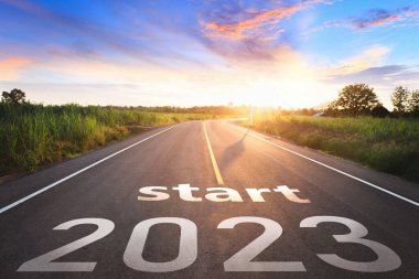 2023 'ü gün batımında asfalt yolun ortasındaki otoyolda yazmaya başla. 2022-2023 için planlama ve meydan okuma kavramı, iş stratejisi, fırsat, umut, yeni bir hayat değişimi..