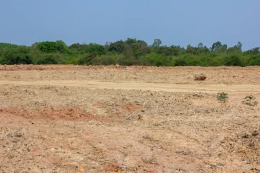 Kuru, çatlak bataklık ıslah toprağı, konut inşaatı için arazi arazi, kırsal alanda araba lastiği izi ve temiz hava ile güzel mavi gökyüzü. Satış arazisi konsepti için arazi.