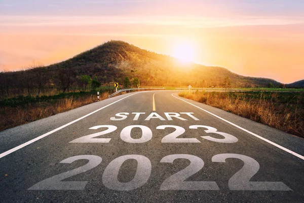 2023 'ü gün batımında asfalt yolun ortasındaki otoyolda yazmaya başla. 2022-2023 için planlama ve meydan okuma kavramı, iş stratejisi, fırsat, umut, yeni bir hayat değişimi..