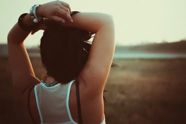 Der Rücken einer attraktiven jungen Frau entspannt sich mit den Händen hinter dem Kopf lizenzfreie Stockbilder