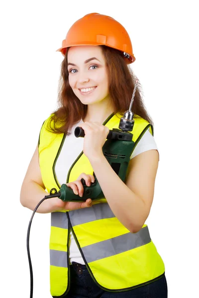 A menina em um colete de construção e um capacete com uma furadeira elétrica . — Fotografia de Stock