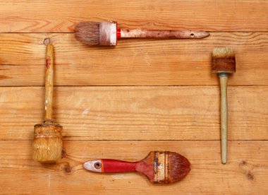 Wooden background with old paint brushes. Placed squares. View from above.