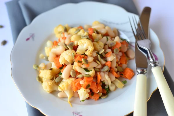 Salada com couve-flor, feijão e abóbora com laranjas e sementes de girassol — Fotografia de Stock
