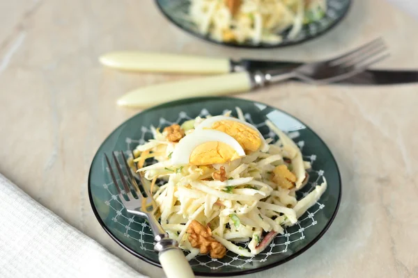 Salad with celery, egg, apple and nuts in bowls