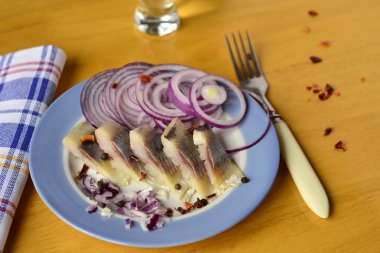 soğan ve ahşap bir masa üzerine biber bölümü ringa balığı filetosu