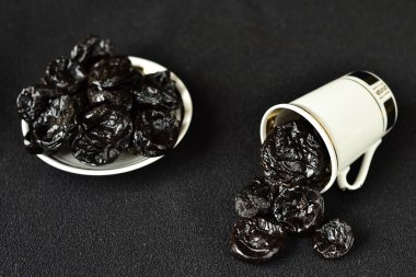 siyah bir arka plan üzerinde beyaz bir bardak kuru erik