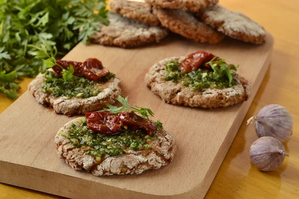 Snacks sandwiches with pesto and sun-dried tomato on rye cakes — Stock Photo, Image