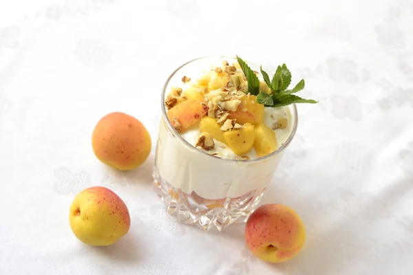 Десерт з сиру з абрикосами, волоськими горіхами та м'ятою — стокове фото