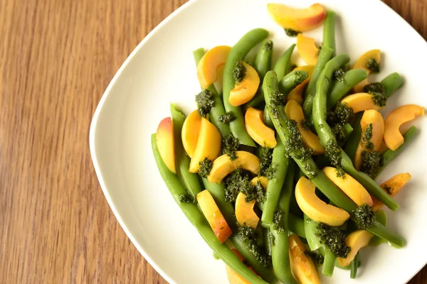 Salad of green beans and apricot with green sauce — Stock Photo, Image