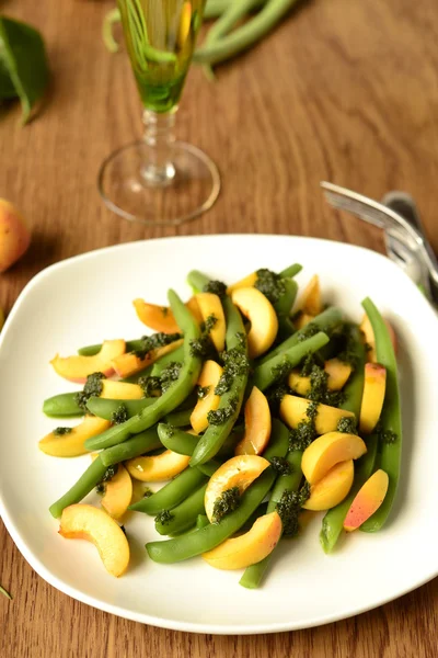 Salad of green beans and apricot with green sauce — Stock Photo, Image