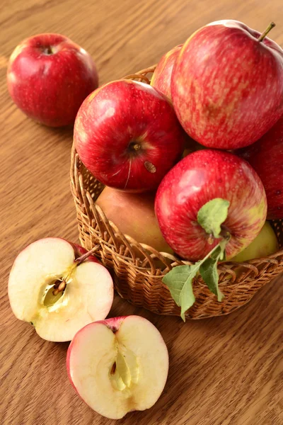 Red apples with leaves in a basket on the table — Stock Photo, Image