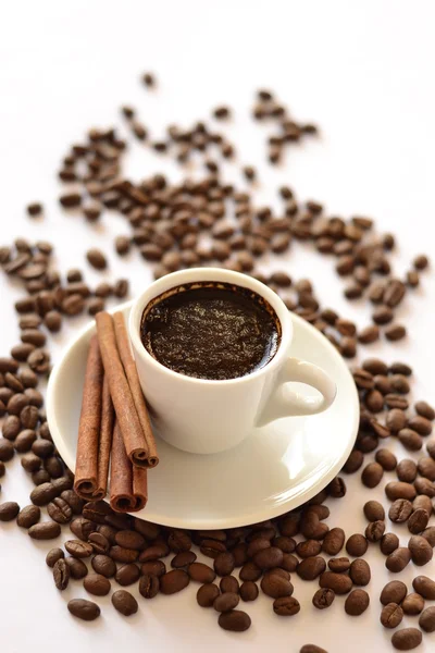 Taza de café, canela sobre un fondo de frijoles —  Fotos de Stock