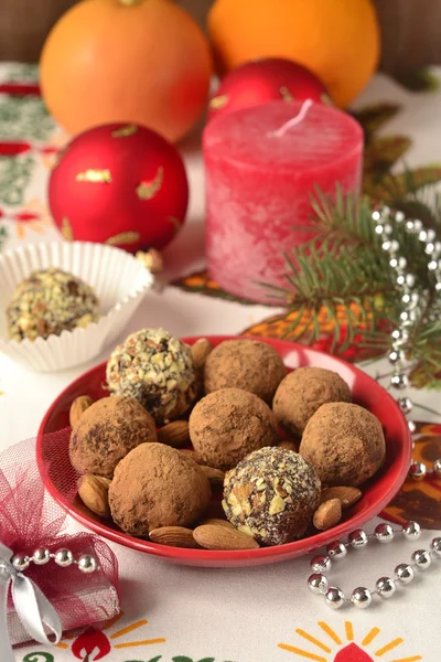 Chocolate truffles on a plate and Christmas decorations — Stock Photo, Image