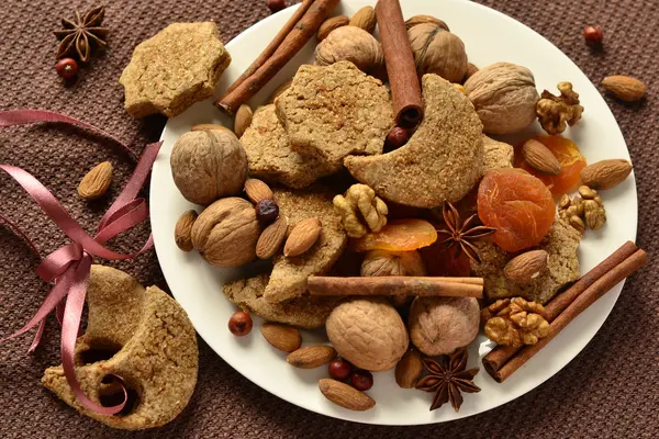 Рождественское печенье, специи и орехи на тарелке — стоковое фото