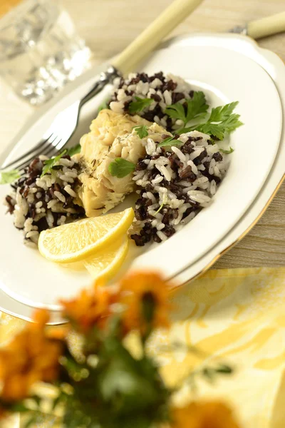 Рыба с розмарином, рисом и ломтиком лимона — стоковое фото
