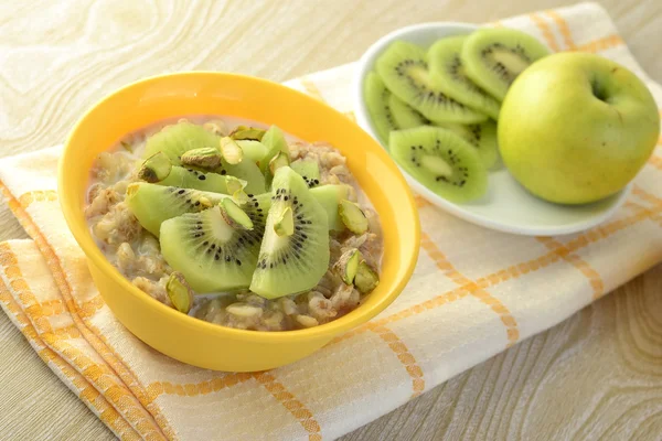 Desayuno saludable: gachas de avena con kiwi y pistachos —  Fotos de Stock