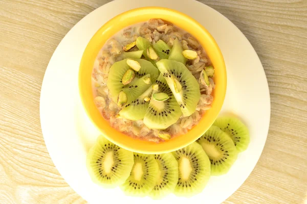Desayuno saludable: gachas de avena con kiwi y pistachos —  Fotos de Stock