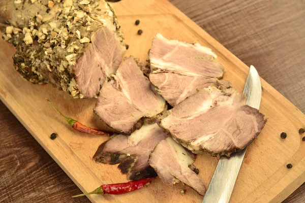 bir kesme tahtası üzerinde baharatlar ile haşlanmış domuz eti