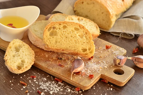 Frisches Brot - Ciabatta, Chili und Knoblauch auf altem Holzbrett — Stockfoto