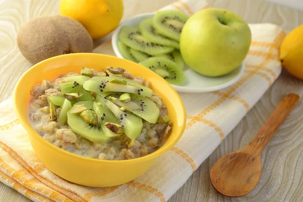 Desayuno saludable: gachas de avena con kiwi y pistachos —  Fotos de Stock