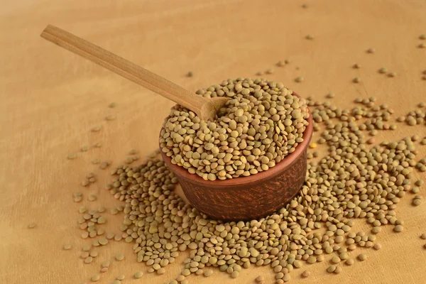 セラミック ボウルと木製のスプーンで穀物のレンズ豆 — ストック写真