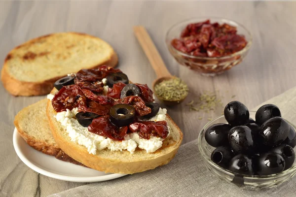 Toast with olives, sun-dried tomatoes and cottage cheese — Stock Photo, Image