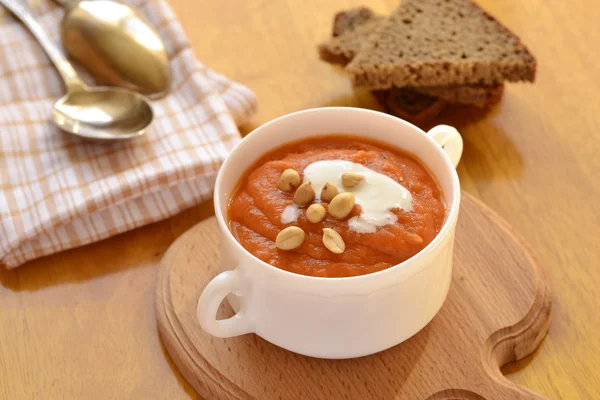 Carrot soup with sour cream and peanuts — Stock Photo, Image