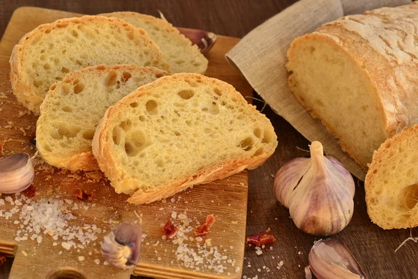 Сiabatta, Chili und Knoblauch auf altem Holzbrett — Stockfoto