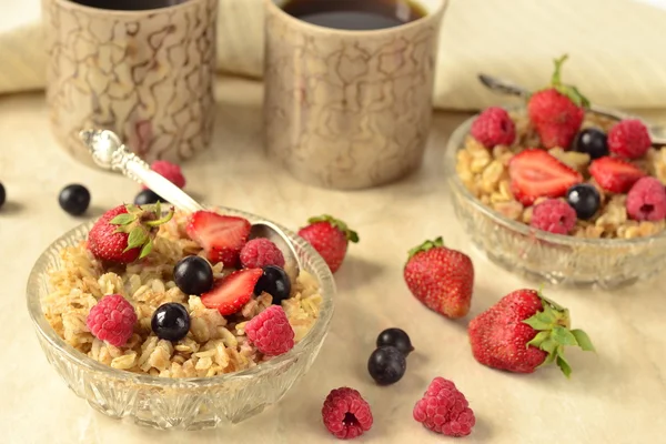 Porridge with grains, fresh berries and tea for breakfast — Stock Photo, Image