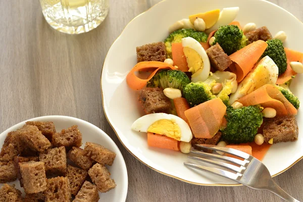 Salad with broccoli, carrots, egg and rye croutons — Stock Photo, Image