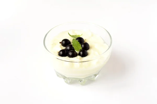 Йогурт с черной смородиной в стакане — стоковое фото