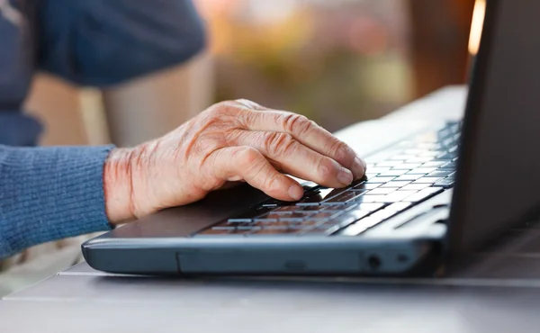 Vecchia mano su un computer portatile — Foto Stock