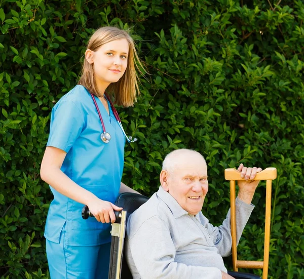 Professionele hulp voor ouderen in rolstoel — Stockfoto